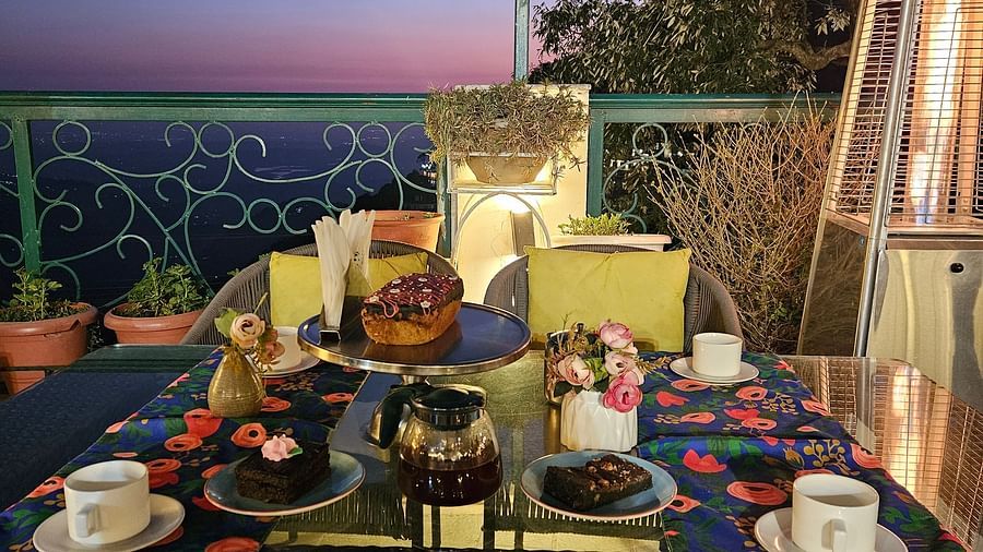A terrace with tables set for dining under ambient lighting, offering sunset views | Mongas Hotel & Resort, Dalhousie 