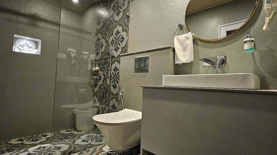 A washroom equipped with a wall mirror, sink, and commode | Mongas Hotel & Resort, Dalhousie