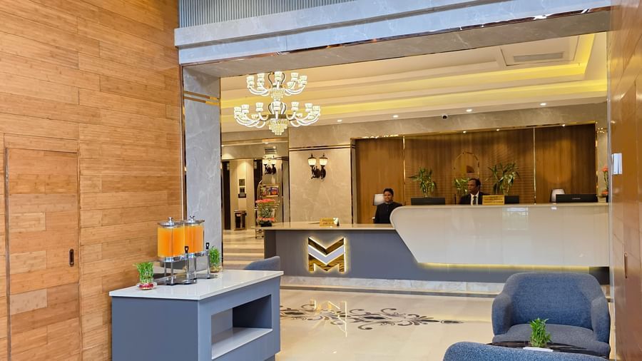The corridor at the lobby of The Meriton featuring the reception desk in the front with the receptionists standing behind the desk.