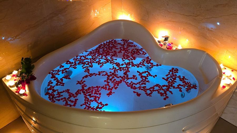 Heart-shaped Jacuzzi tub with flower petals and candles at The Verda de Miranda Resort.