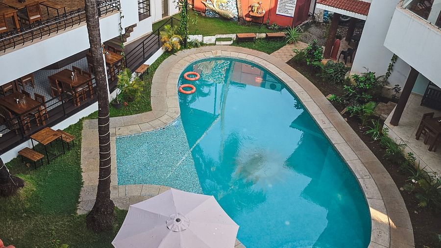 Top view of a narrow swimming pool bordered by loungers and umbrellas at The Verda de Miranda Resort.