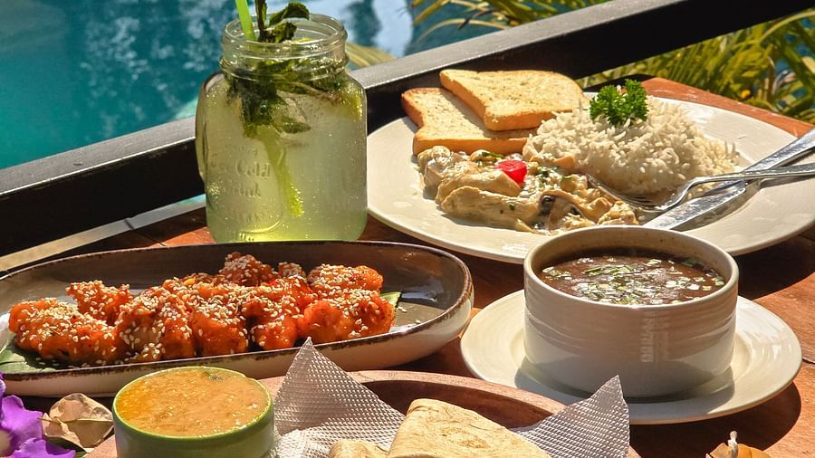 A scenic poolside meal featuring sandwiches, dips, and drinks surrounded by lush greenery – The Verda de Miranda Resort.