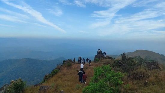 trekkers walking along a with mountain in sakleshpur