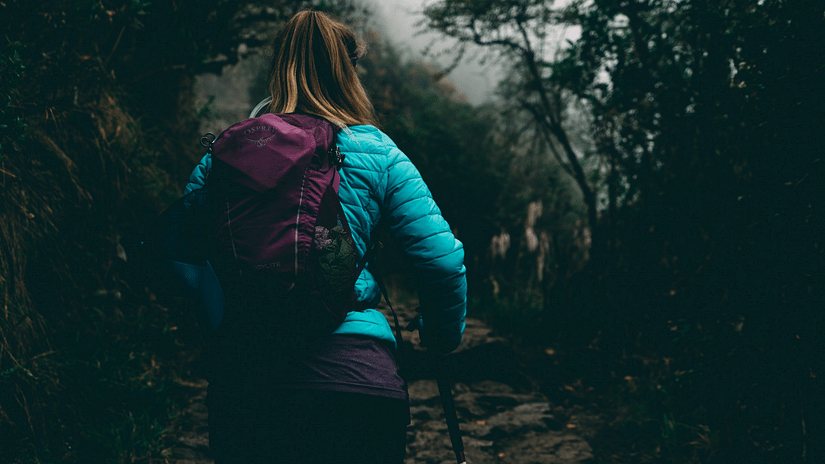 A woman trekking in the jungle wearing protective gear