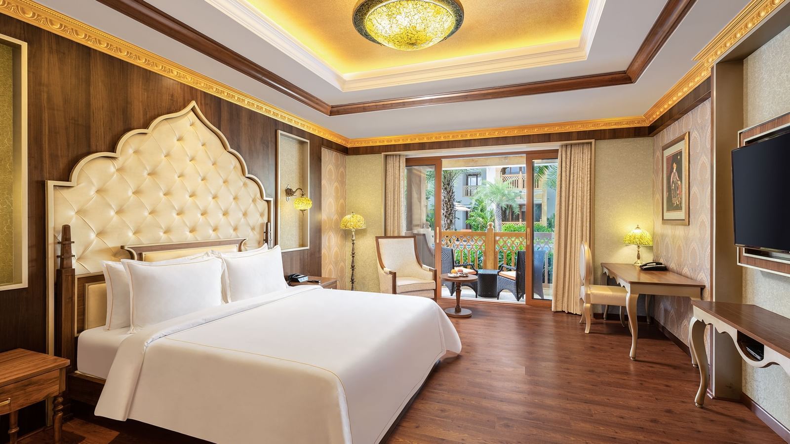 A hotel room in Mahabalipuram with rich wooden flooring, a large bed, and comfortable seating arrangement – Kaldan Samudra, one of the finest Mahabalipuram beach resorts