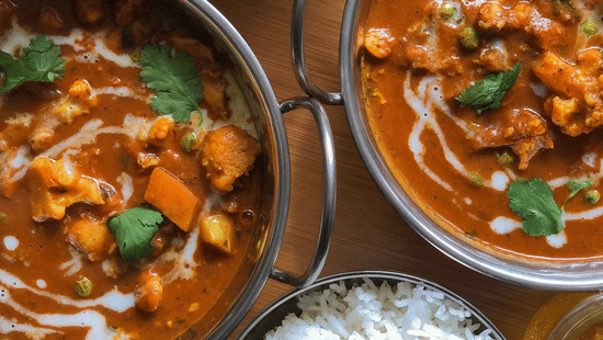 Assorted Indian dishes served in bowls with rice showcasing dining experience at The Pride Premier Nagpur.