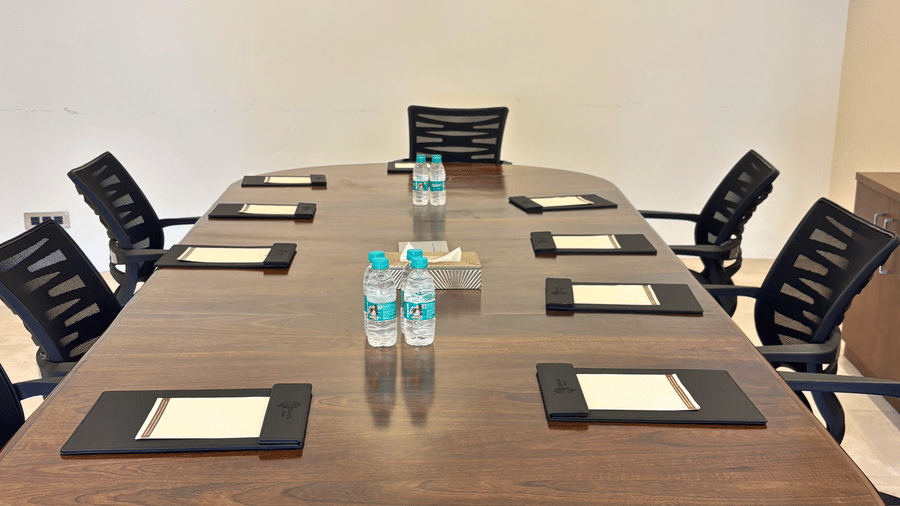 Close up of a meeting room at Kadamb Kuteer, Vrindavan with a large oval conference table and several office chairs.