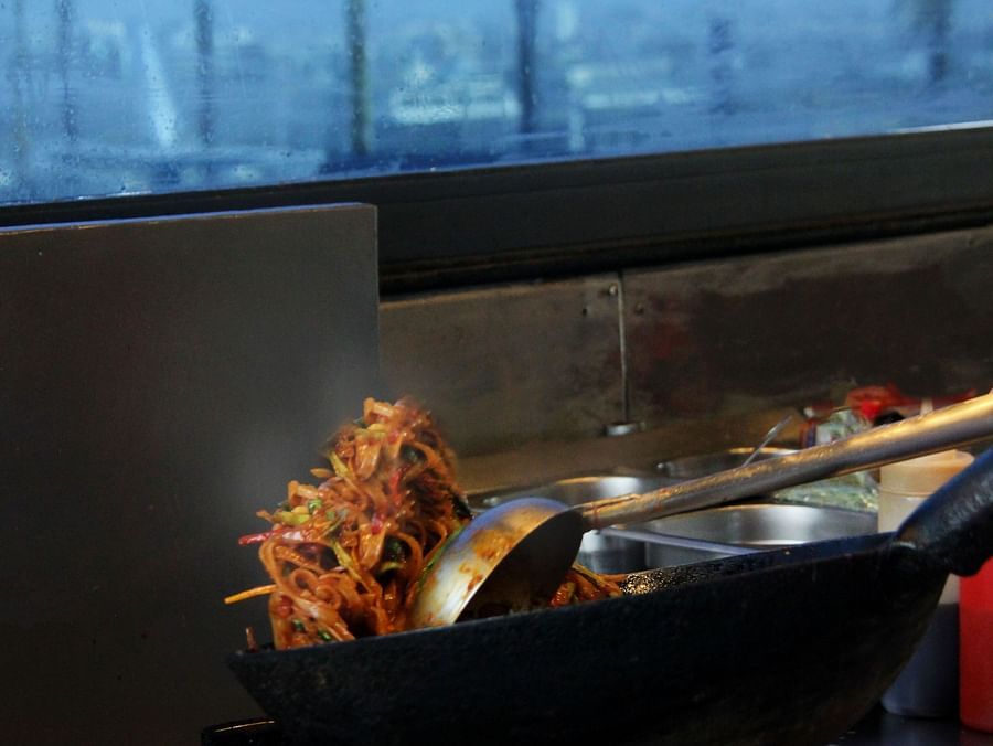 A chef stir-frying food in a wok.