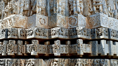 Vertical rows of detailed sandstone sculptures depicting deities and figures adorn the facade of a historic temple.