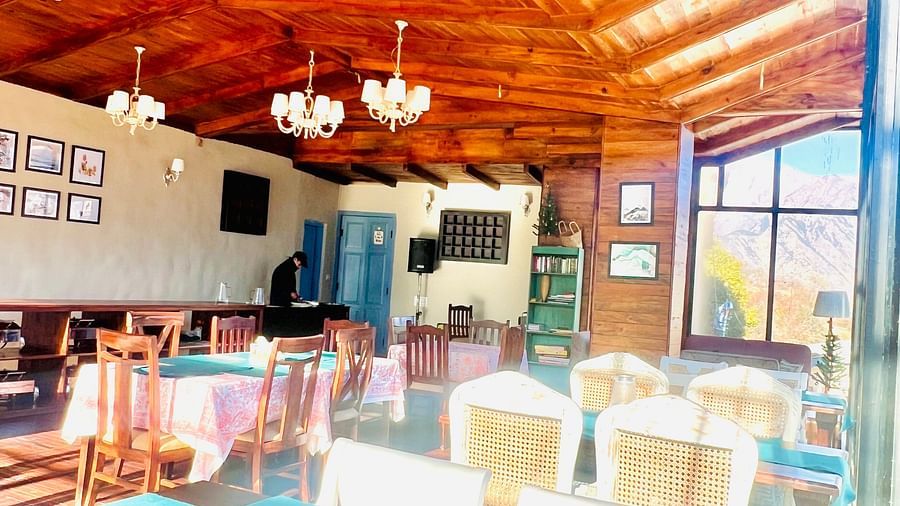 Image of dining area with wooden ceiling and chandeliers | Faraway Cottages, Auli