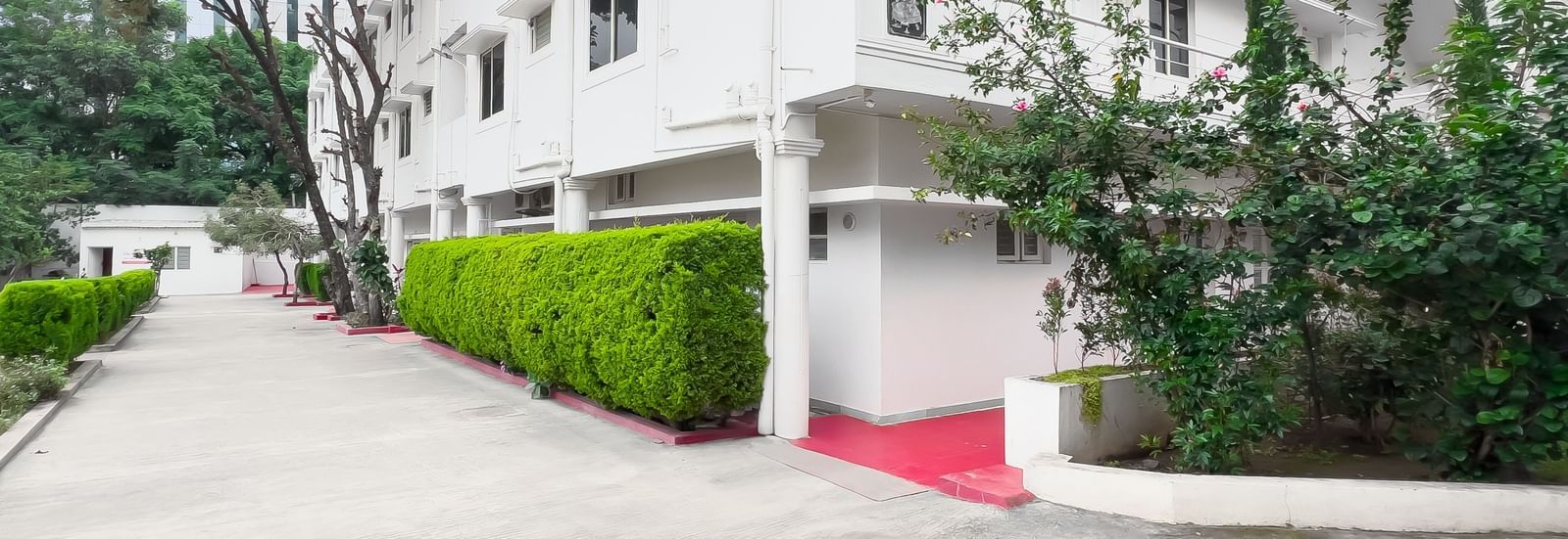 Front view of residential building with pathway and plants at The Pinnacle, Electronic City.