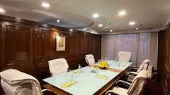 A meeting room at The Bristol Hotel, Gurgaon featuring a conference table surrounded by six chairs