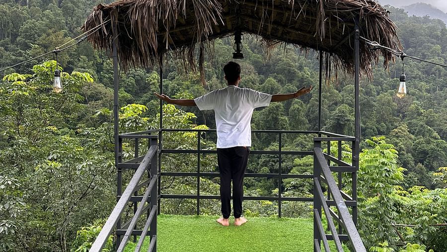 a person posing in the balcony of the tower stay - Holistic Stay Eco Resort, Kannur