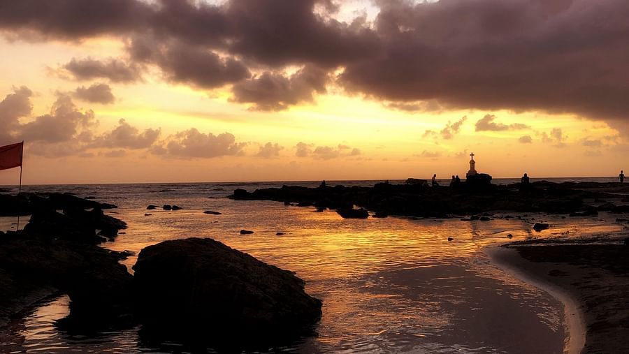 The golden hue of the sunset reflects on the water at Morjim Beach - Best Places to Visit in Morjim