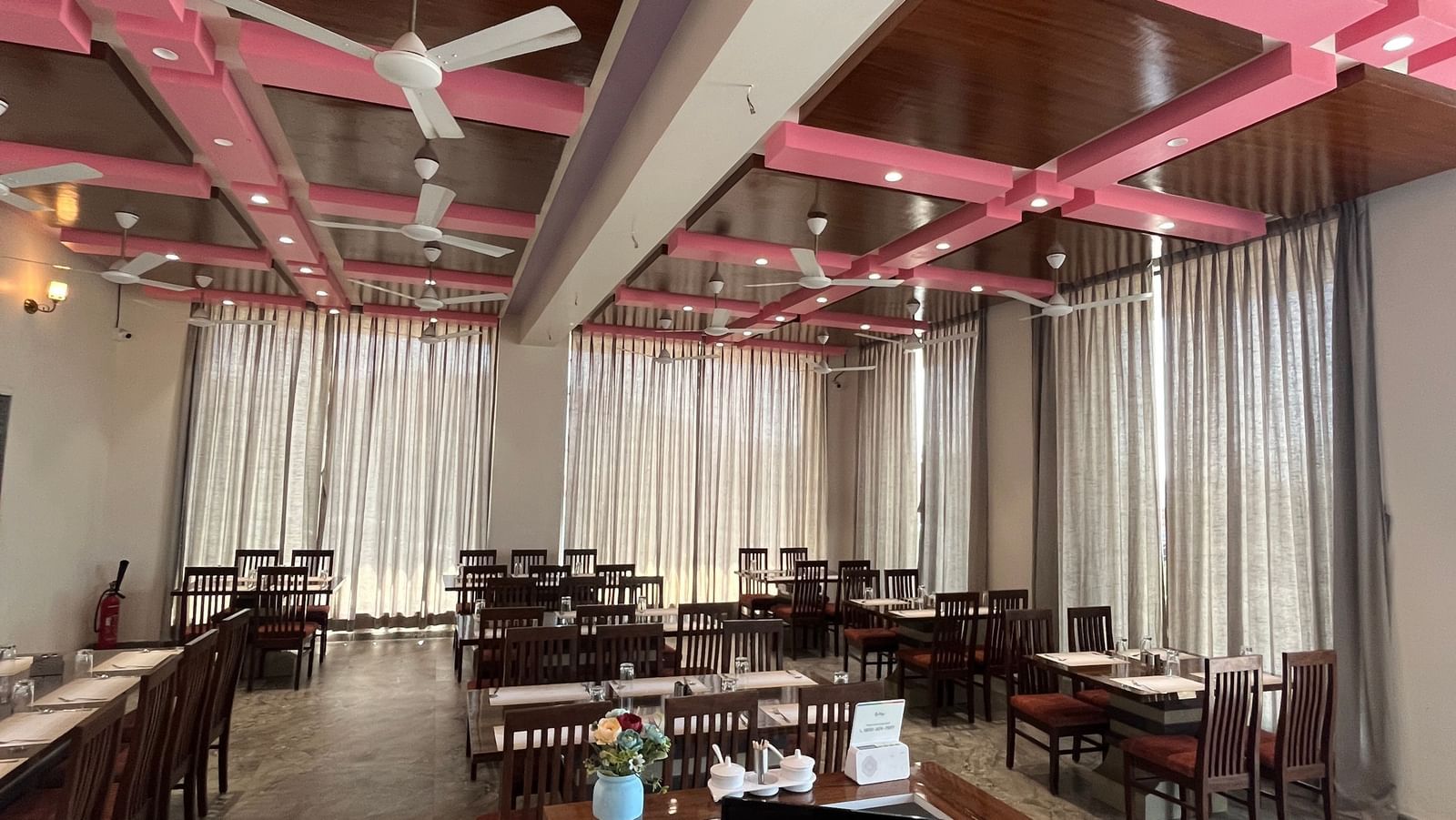 Extended view of the neatly arranged tables in the fine-dining restaurant at Daksh The Valley Resort, Saputara.