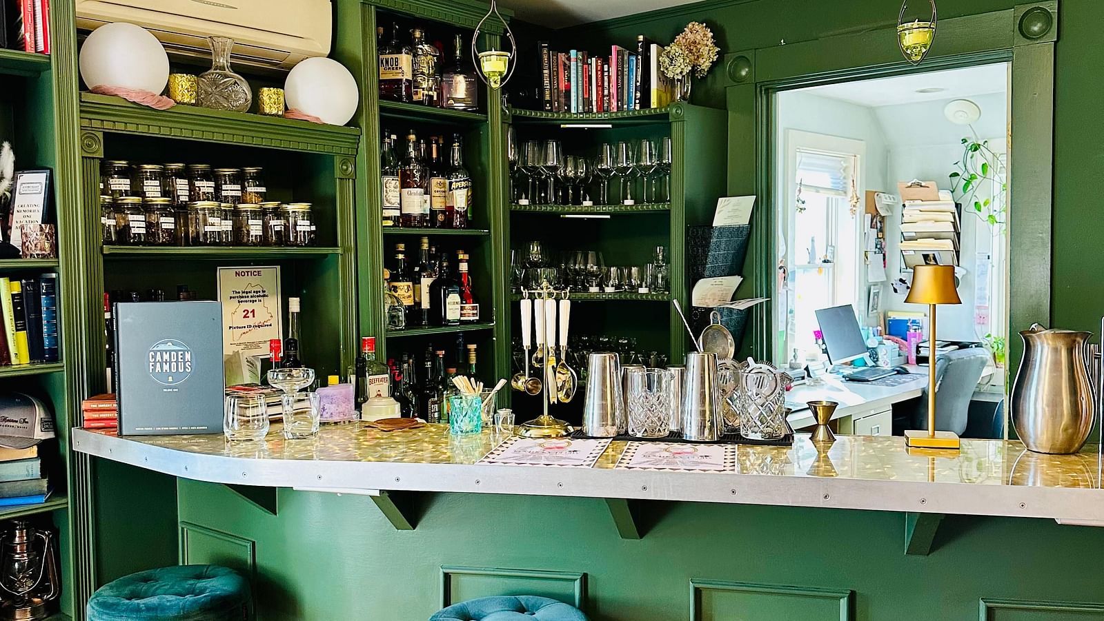 Stylish bar area at Hartstone Inn with teal stools, green cabinetry, and a well-stocked back bar in an intimate setting.
