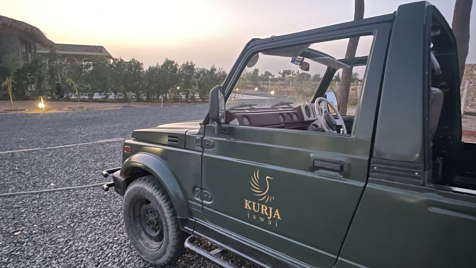 Side view of  a safari jeep with tree behind