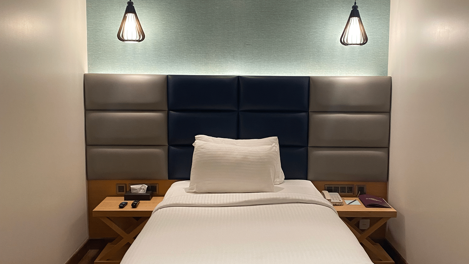 A comfortable bed with beautiful hanging light at SRM Hotel Maram Malai Nagar Chennai