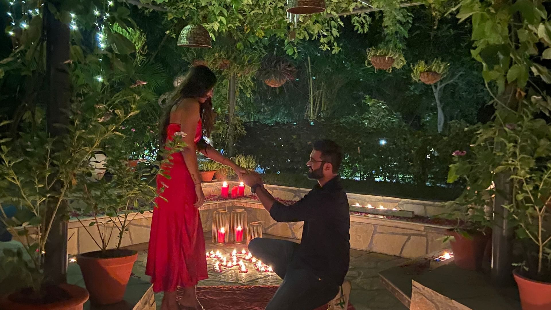 Guest proposing under candlelight in a romantic outdoor setting at Karma Chalets.