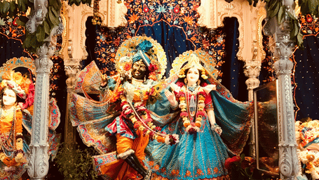 Decorated shrine of Radha-Krishna, embellished with flowers, fabrics, and lights