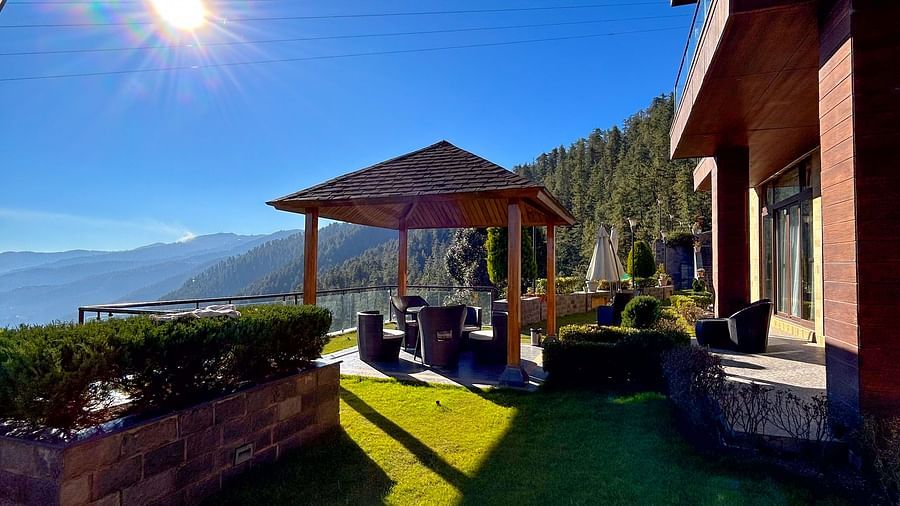 Sunny day view of a peaceful gazebo surrounded by Himalayan hills at Aranya Retreat, Mashobra