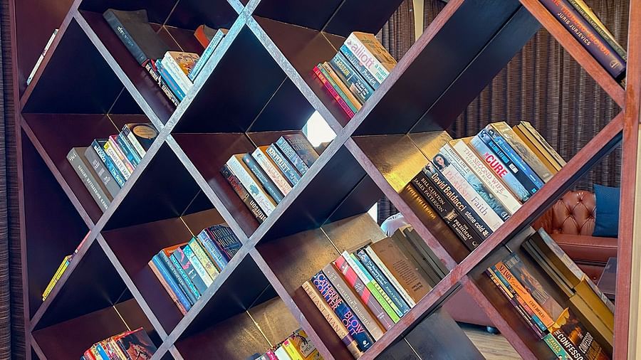 Contemporary wooden bookshelf filled with books in the cozy reading lounge at Aranya Retreat, Mashobra