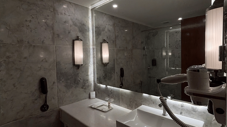 Modern bathroom fixtures including a double-width vanity and bright mirror lighting furnish the Deluxe Twin suite at Clarks Amer, Jaipur.