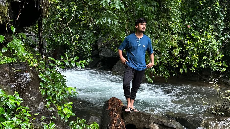 a person near a stream with a log in front of him - Holistic Stay Eco Resort, Kannur