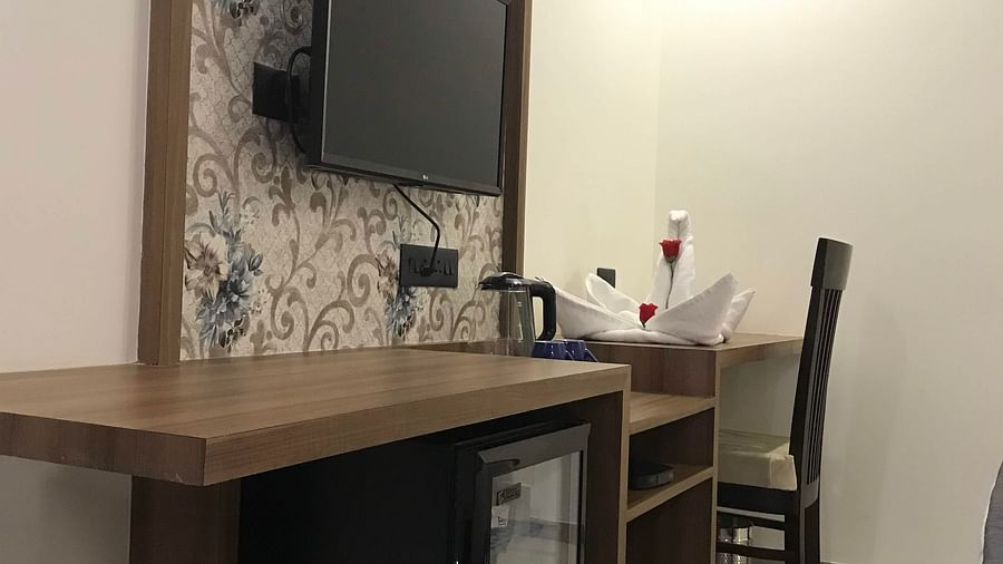 A desk, TV and chair | Kyriad Hotel, Solapur
