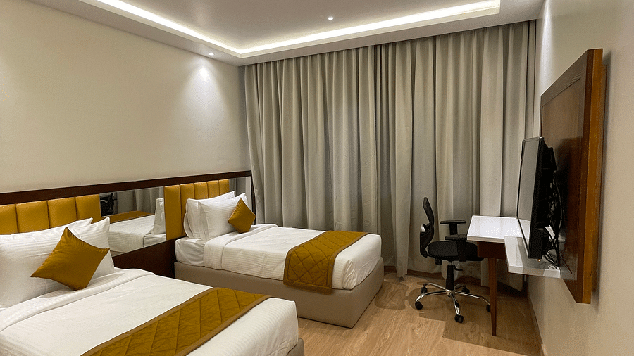 Bedroom with twin beds and chair and table-  Quality Inn Rockwell Grand