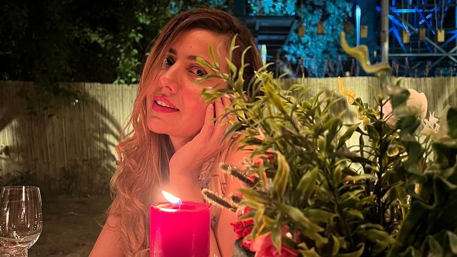 a woman sitting by a lit up candle at Themis Mudhouse - A Nature's Retreat Resort & Wellness