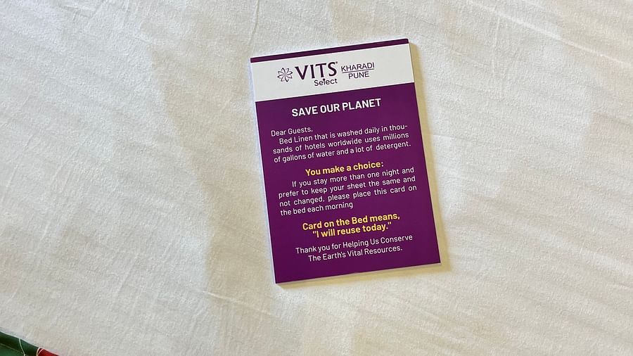 A image of a card with the name of the hotel placed on a bed at VITS Select Kharadi, Pune.