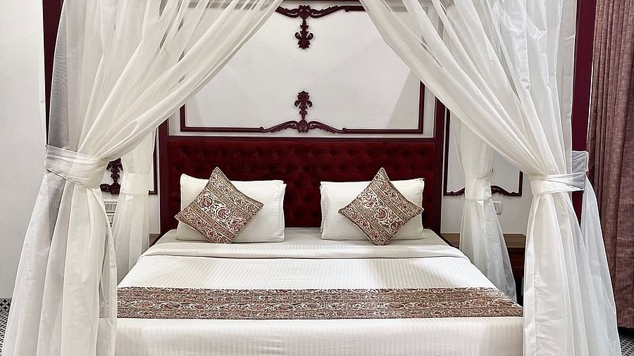 a king size bed with white drapes around it 1 - Zara's Resort