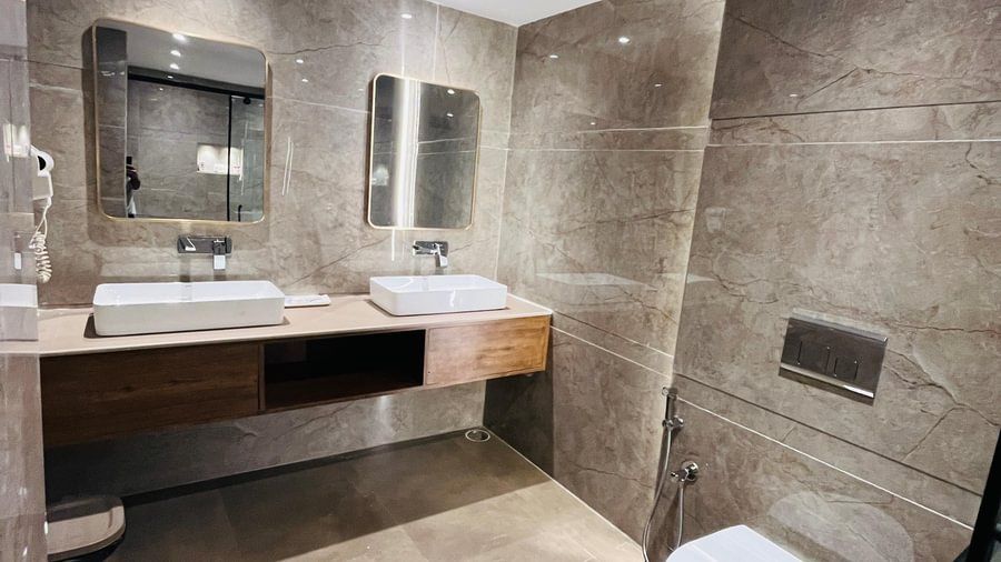 Modern bathroom vanity area in the Andaman Exotica with a large mirror and stone countertop.