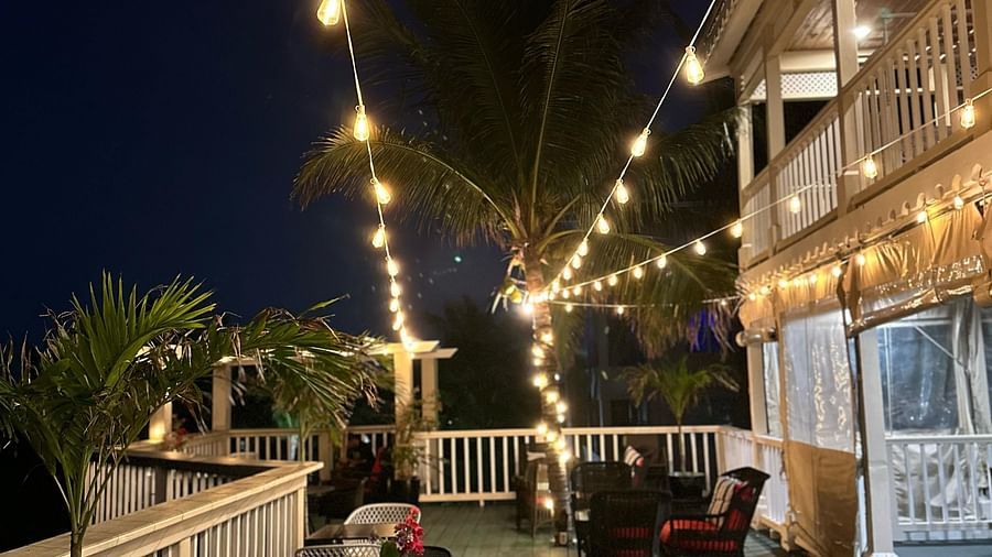 Outdoor deck with tables and string lights illuminated at night | A Stone's Throw Away