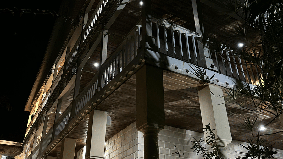 Building exterior at night lit by warm lights of A Stone's Throw Away