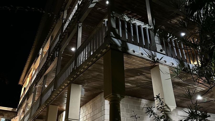 Building exterior at night lit by warm lights | A Stone's Throw Away