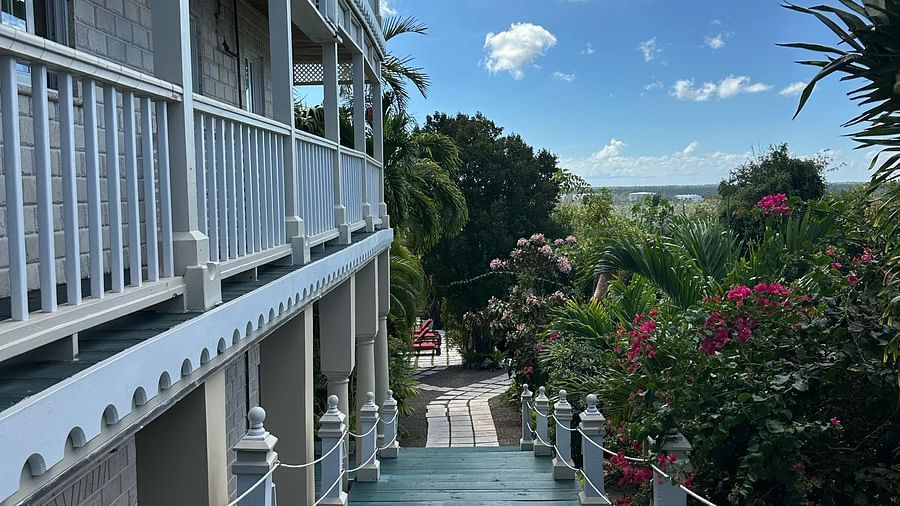 Exterior corridor with white railings and garden path below | A Stone's Throw Away