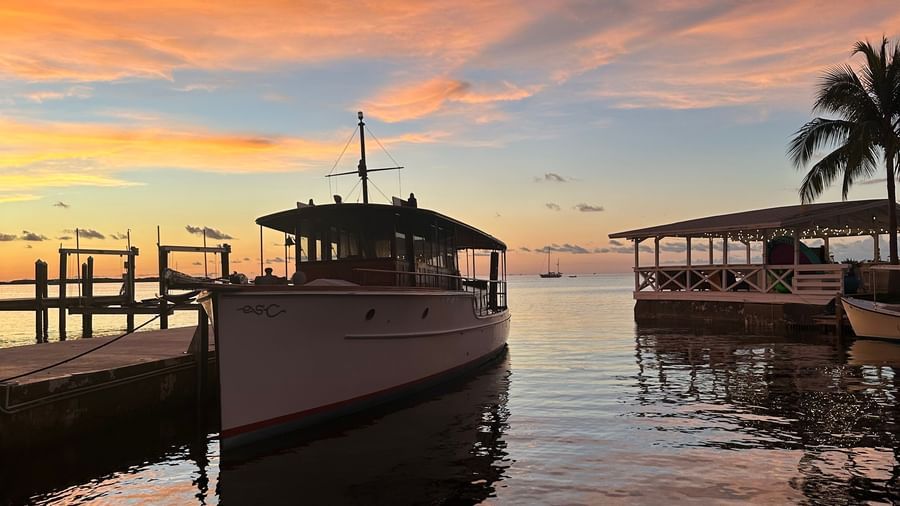 A silhouette of a sail boat docked in the calm waters with a mesmerizing sunset in the background at Casa Morada.