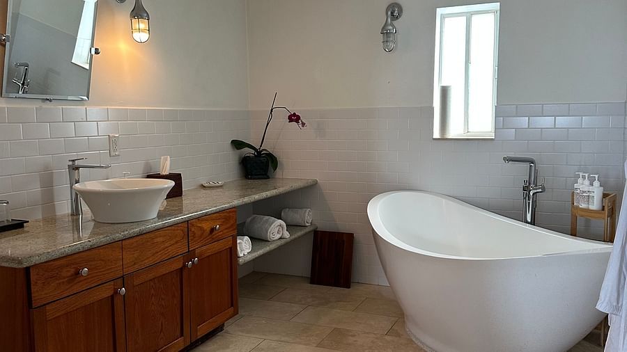 a bathroom with tiled floor, a bathtub, a sink, a cupboard and a mirror at casa morada.