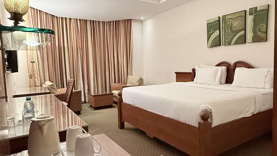 A spacious room with a large bed and a side table holding a tray of essentials | Cenneys Gateway