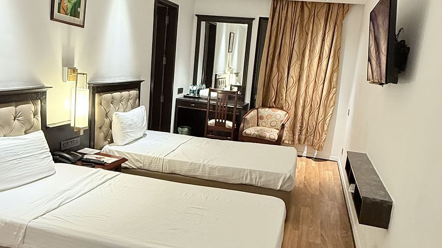 A spacious room with twin beds and a wall-mounted TV opposite them | Cenneys Gateway
