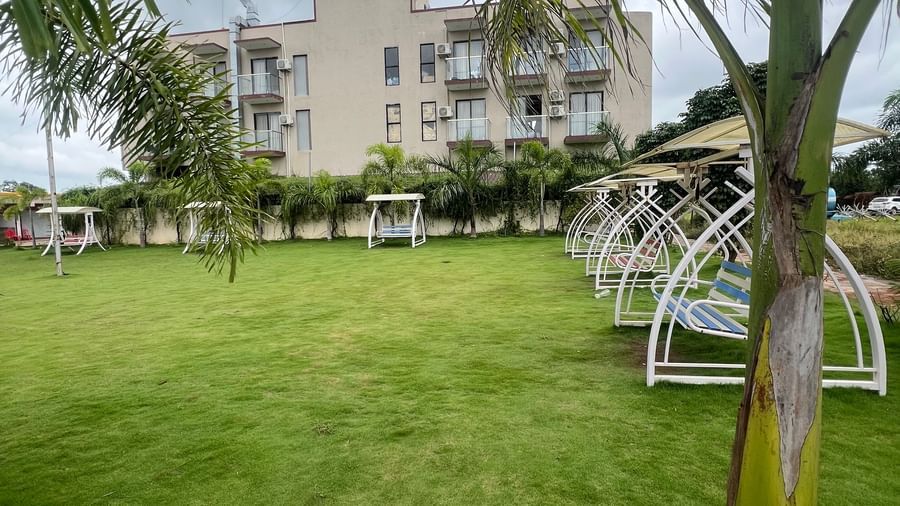 Expansive view of the lawn and multi-storey structure of Daksh The Valley Resort, Saputara, as seen on a cloudy area.