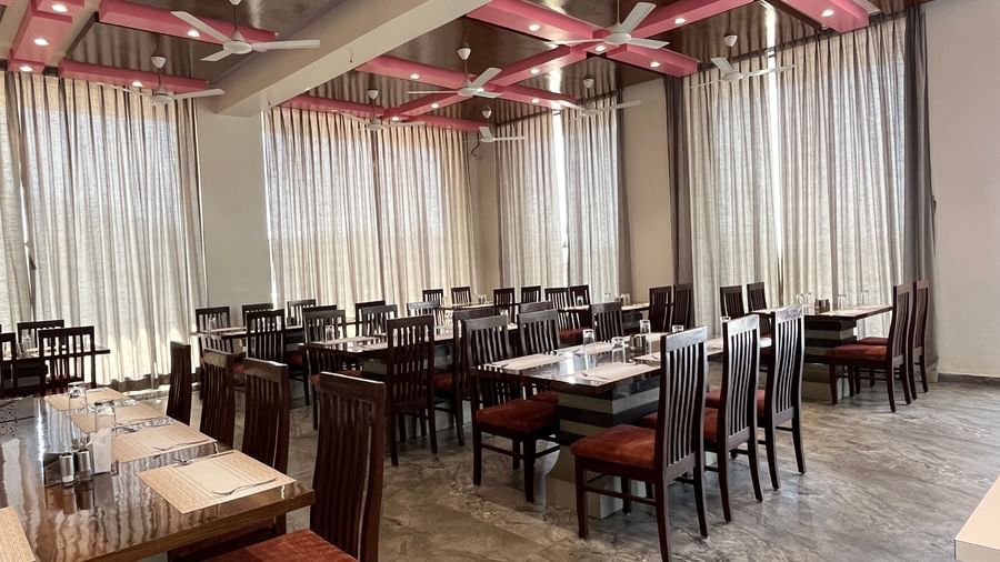 Extended view of the spacious and neatly arranged tables in the fine-dining restaurant at Daksh The Valley Resort, Saputara.