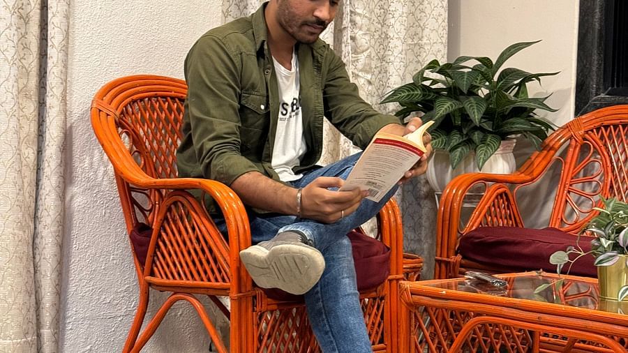 Young man using a laptop in a casual indoor seating area with rattan furniture  | Diamond Parks, Pune 
