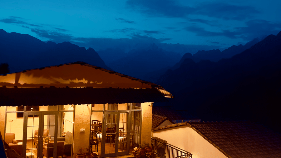 Cosy outdoor dining area lit up at dusk with mountain views at Faraway Cottages, Auli.