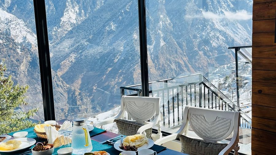 Image of the dining area with food on the table and view of the mountians | Faraway Cottages, Auli