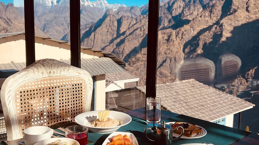 Image of a variety of food on a table and veiws of the mountian | Faraway Cottages, Auli