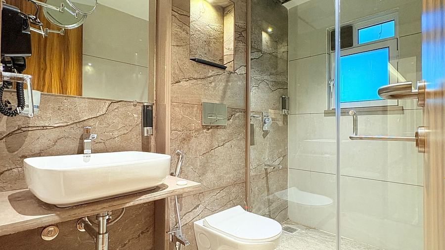 Bathroom featuring a wash basin, shower space, and mirror at Hotel Mumbai House, Vashi.