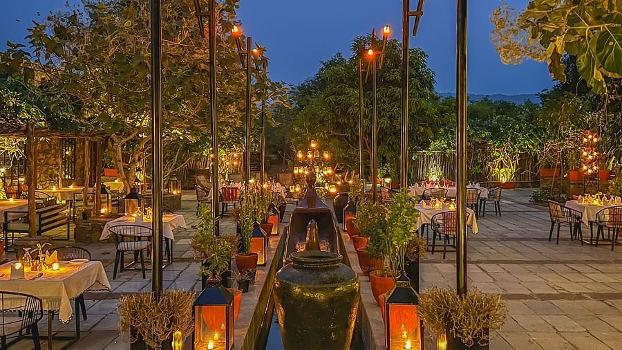 A facade image of an outdoor seating at the hotel with decorative lighitng - Utsav Camp Sariska